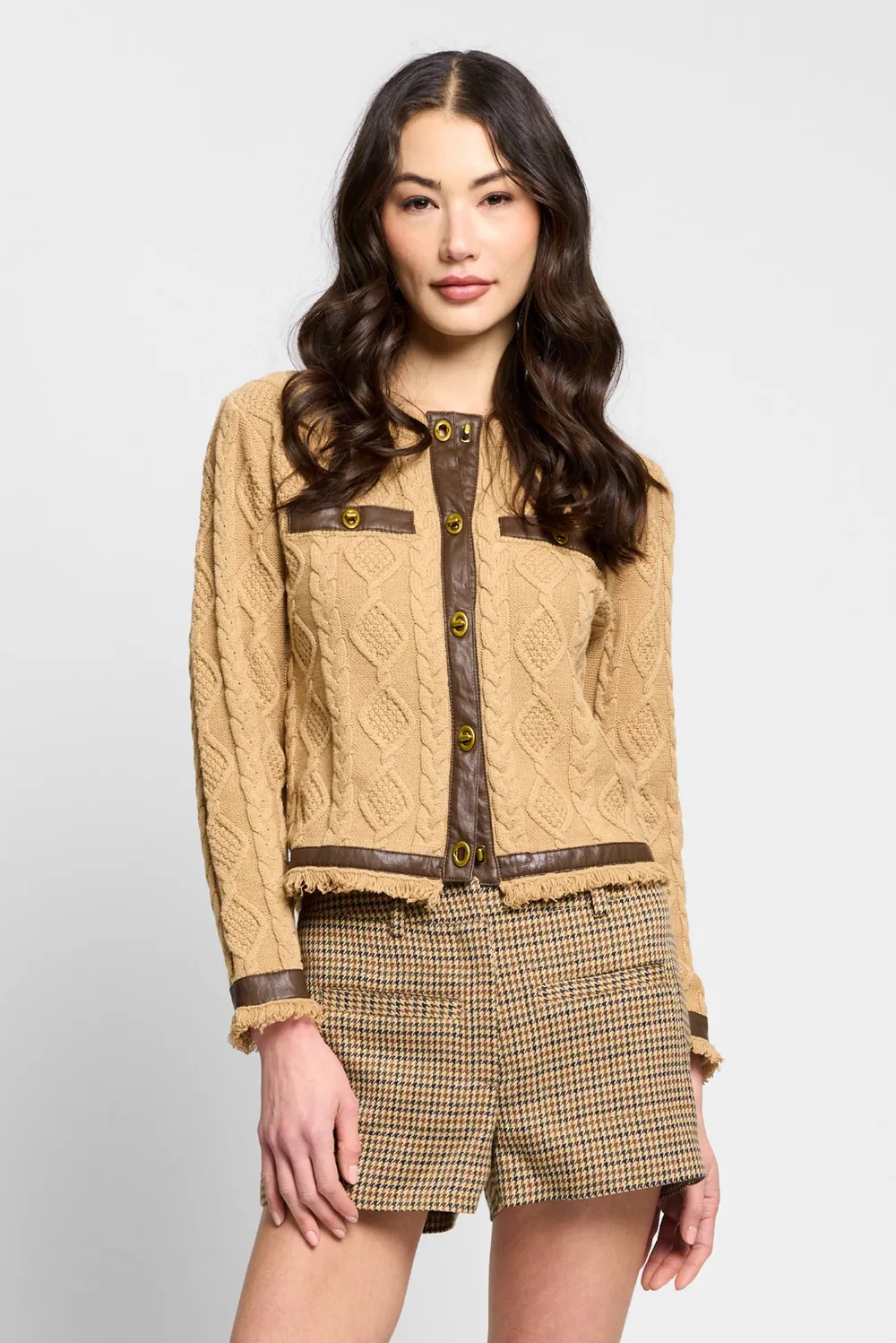 A Central Park West camel cable cardigan with gold buttons